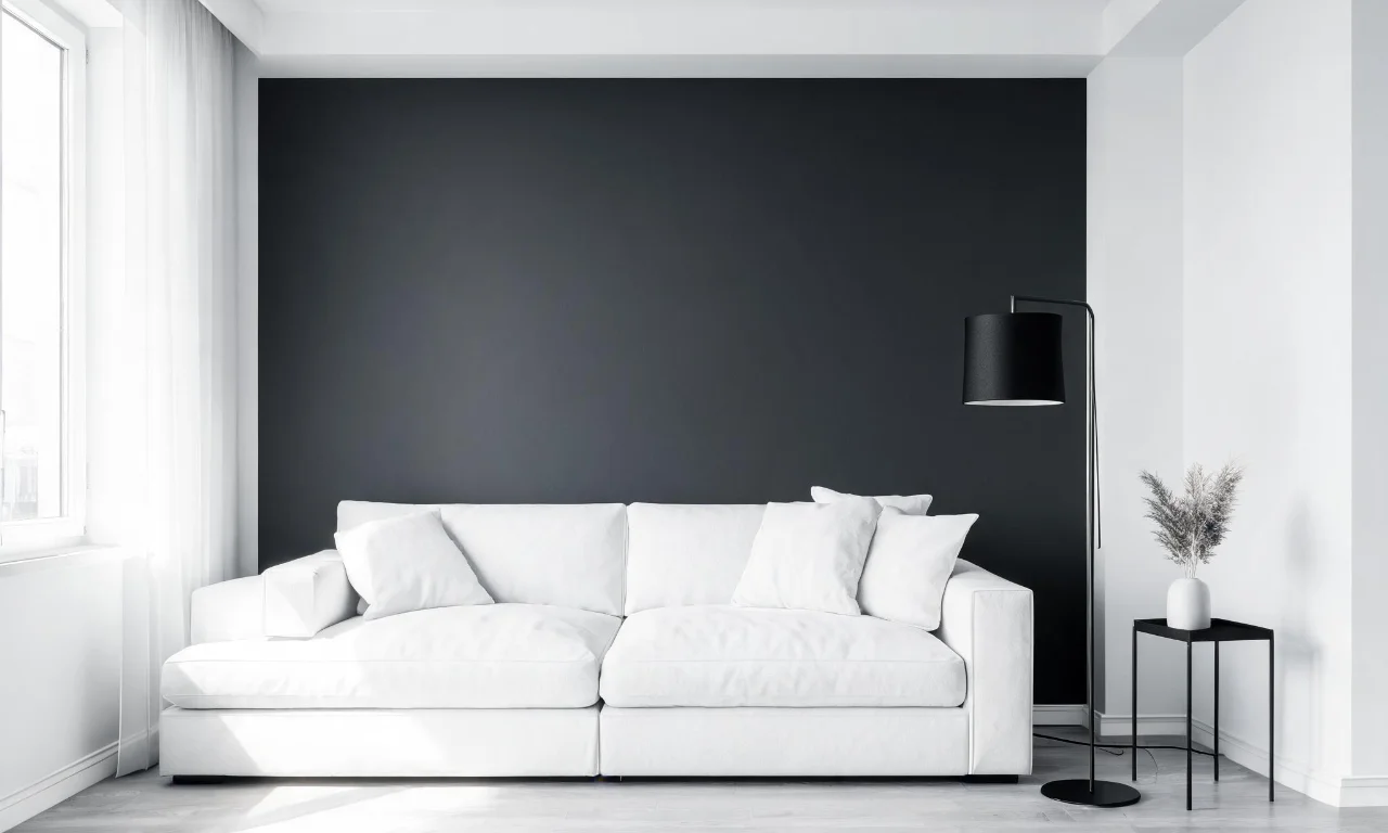 A monochrome living room with a charcoal accent wall, white sofa and a black metal floor lamp.