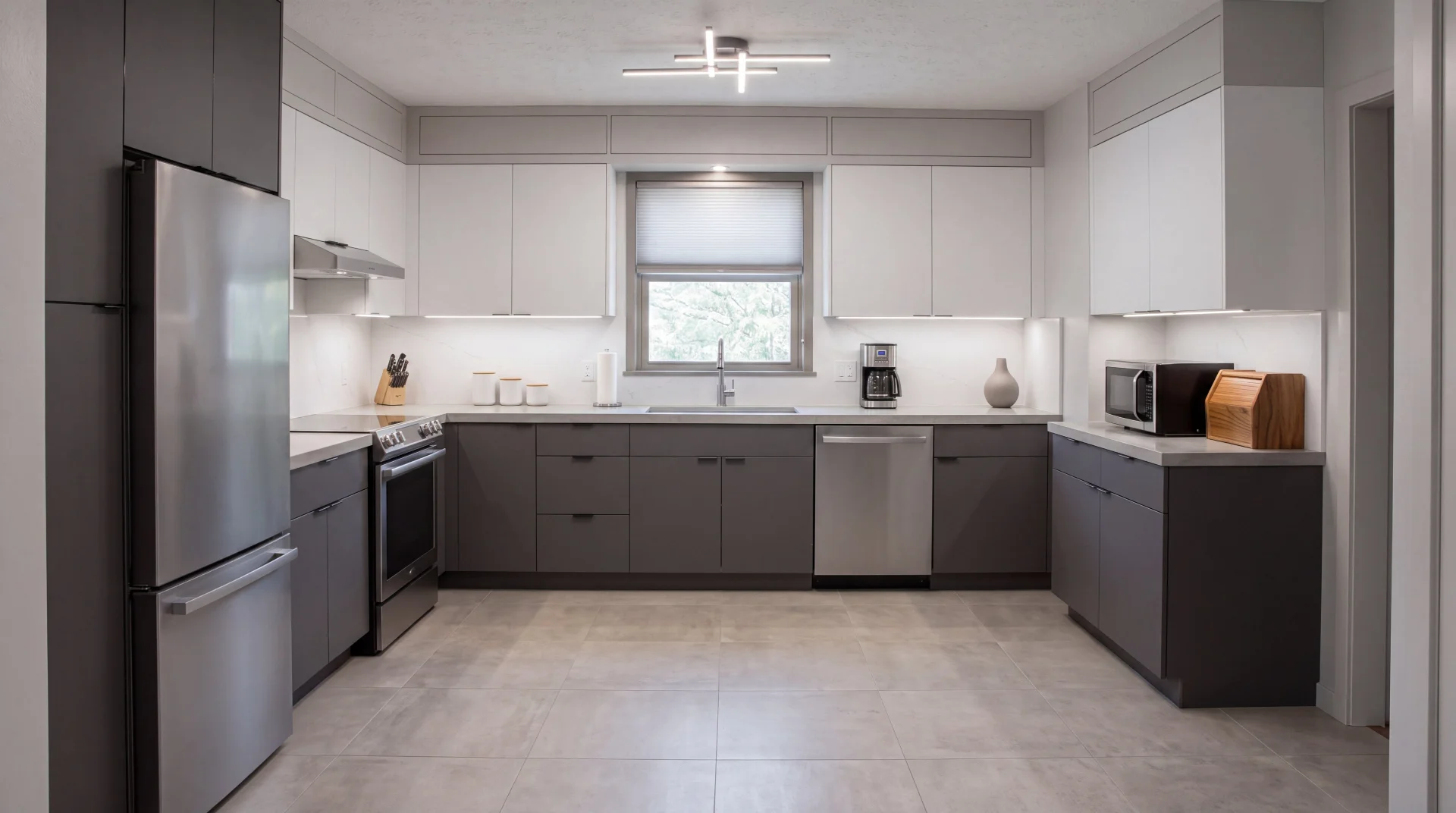 Modern minimalist kitchen with charcoal gray base cabinets, flat-panel white upper cabinets, and stainless steel appliances.